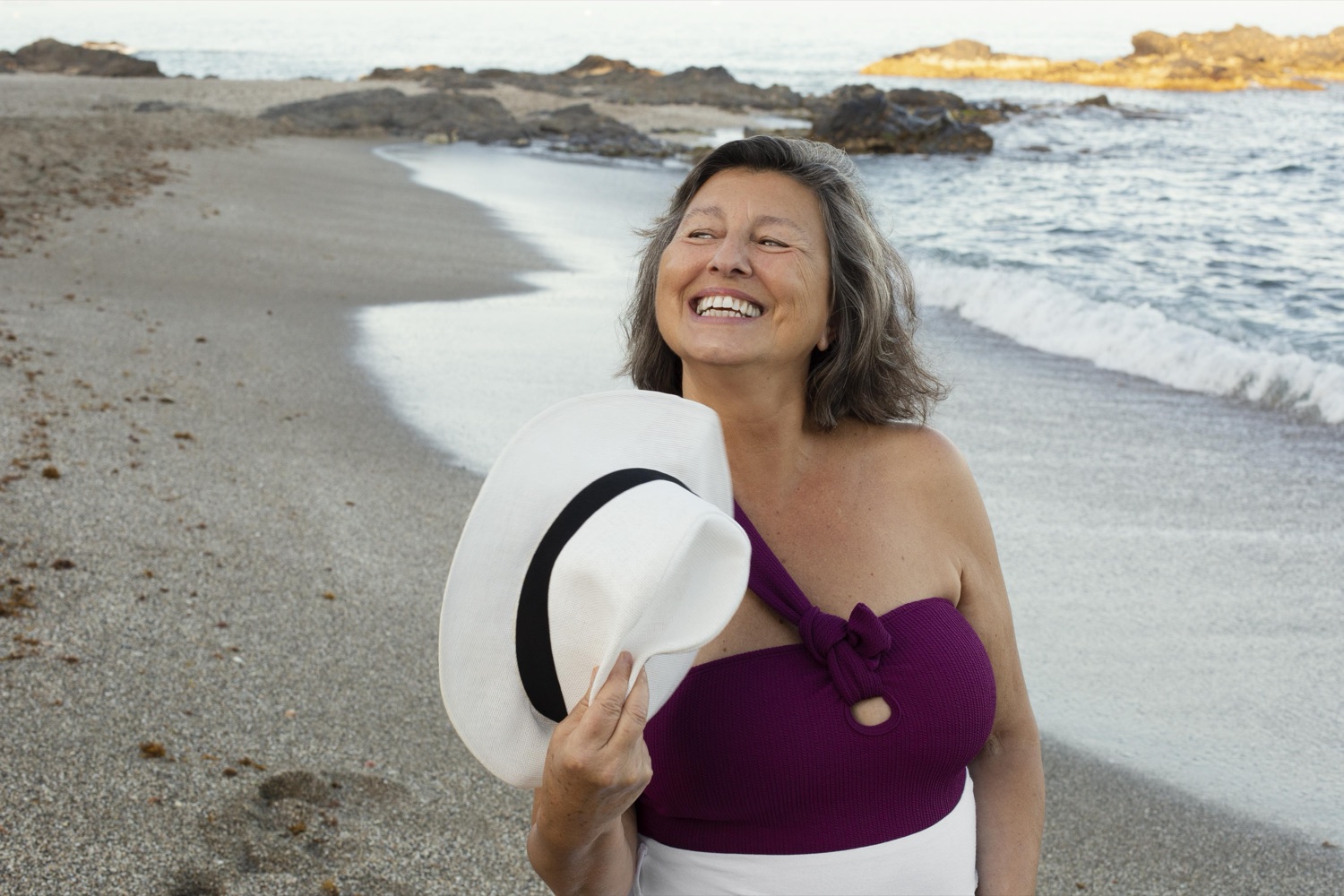 Donna anziana sorridente all'aperto con pelle in salute — benessere dermatologico Paidos