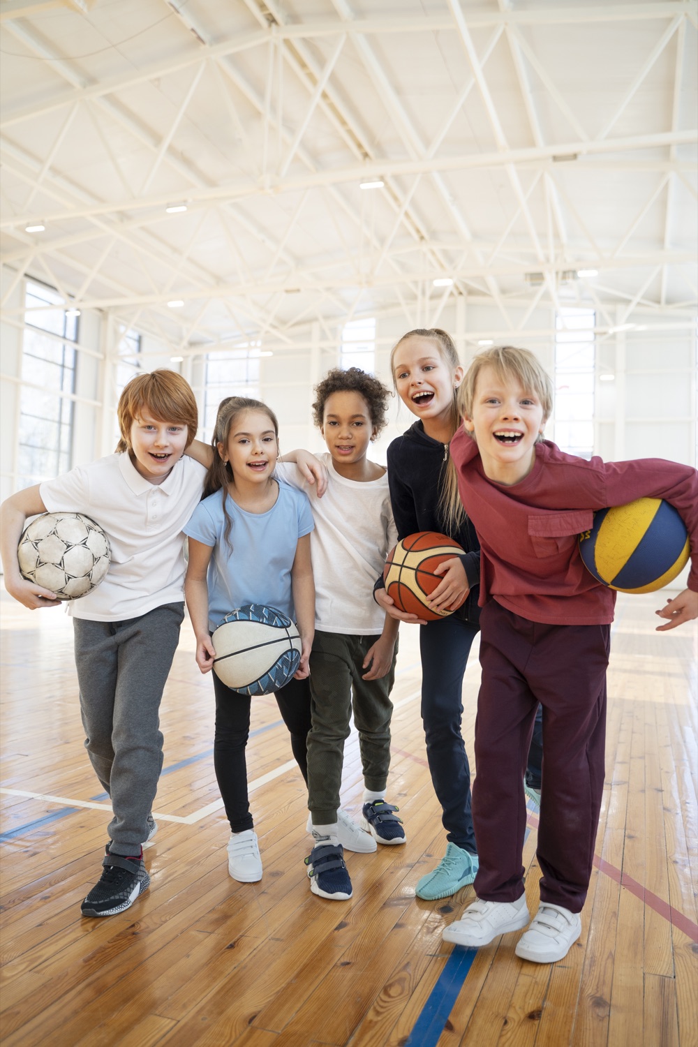 Bambini felici con palloni sportivi in palestra — medicina sportiva Paidos